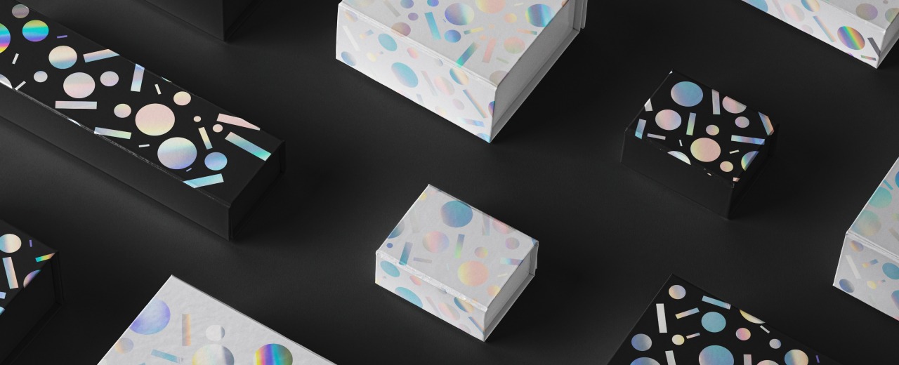 białe i czarne pudełka z geometrycznym wzorem z folii holograficznej