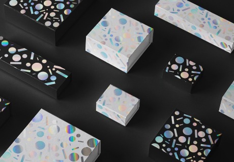białe i czarne pudełka z geometrycznym wzorem z folii holograficznej